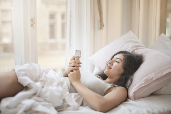 Frau liest Guten-Morgen-Gruß in WhatsApp